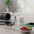 Health and fitness items including a water bottle, Metabolics Magnesium Citrate Malate supplement container, and fruits on a wooden surface.