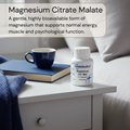 Bottle of Metabolics Magnesium Citrate Malate on a nightstand with a cup and book.