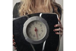 woman holding scales weight health